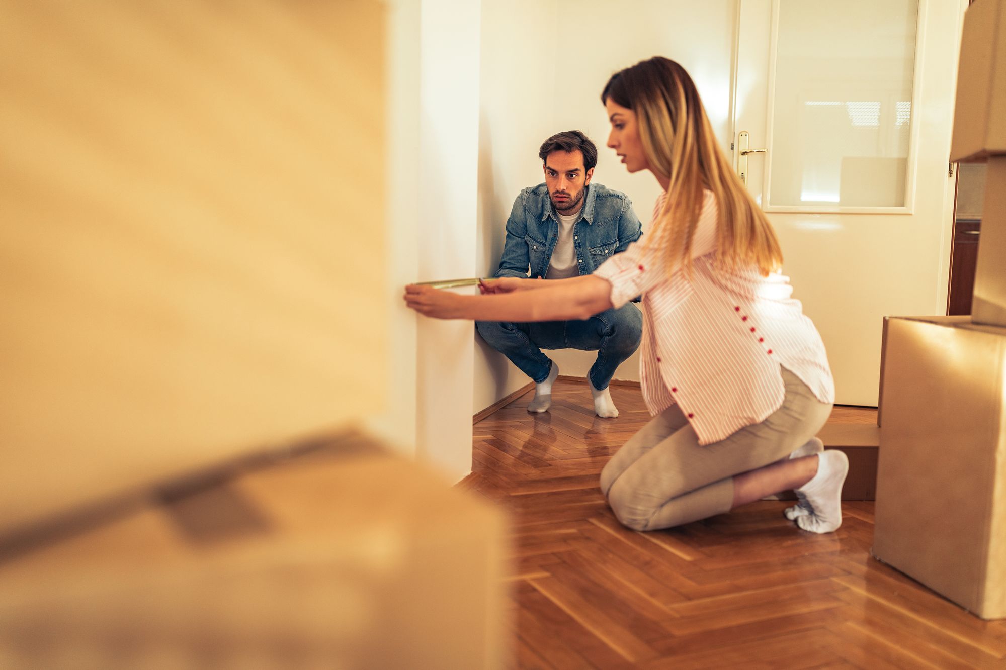 Mulher e homem em casa medindo parede