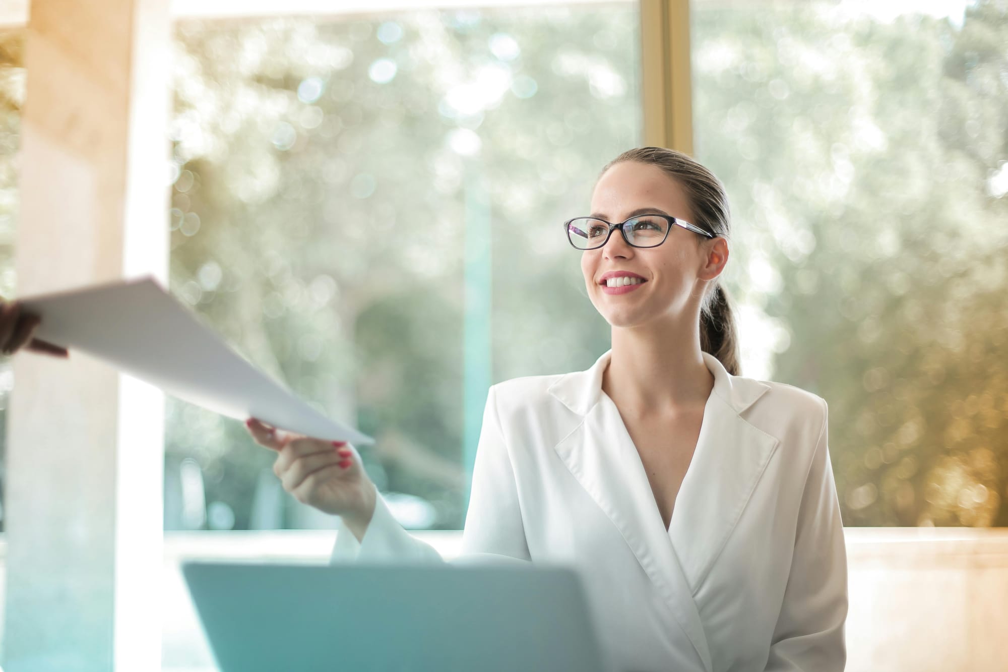 mulher que trabalha como administradora imobiliária entregando um papel 