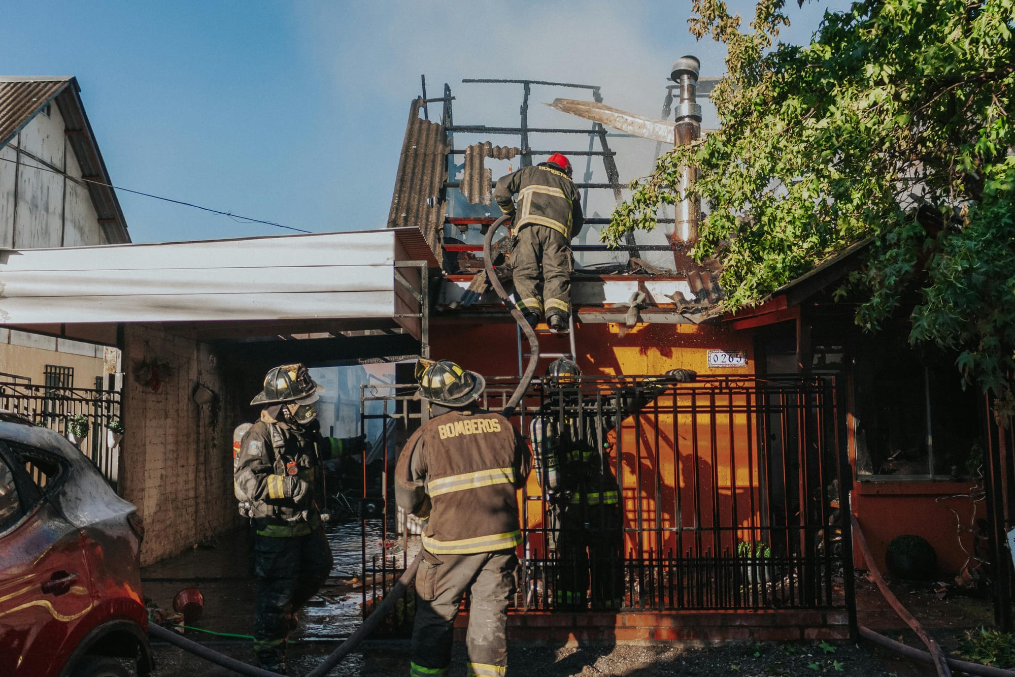 Bomdeiros  apagando incêndio em residência.